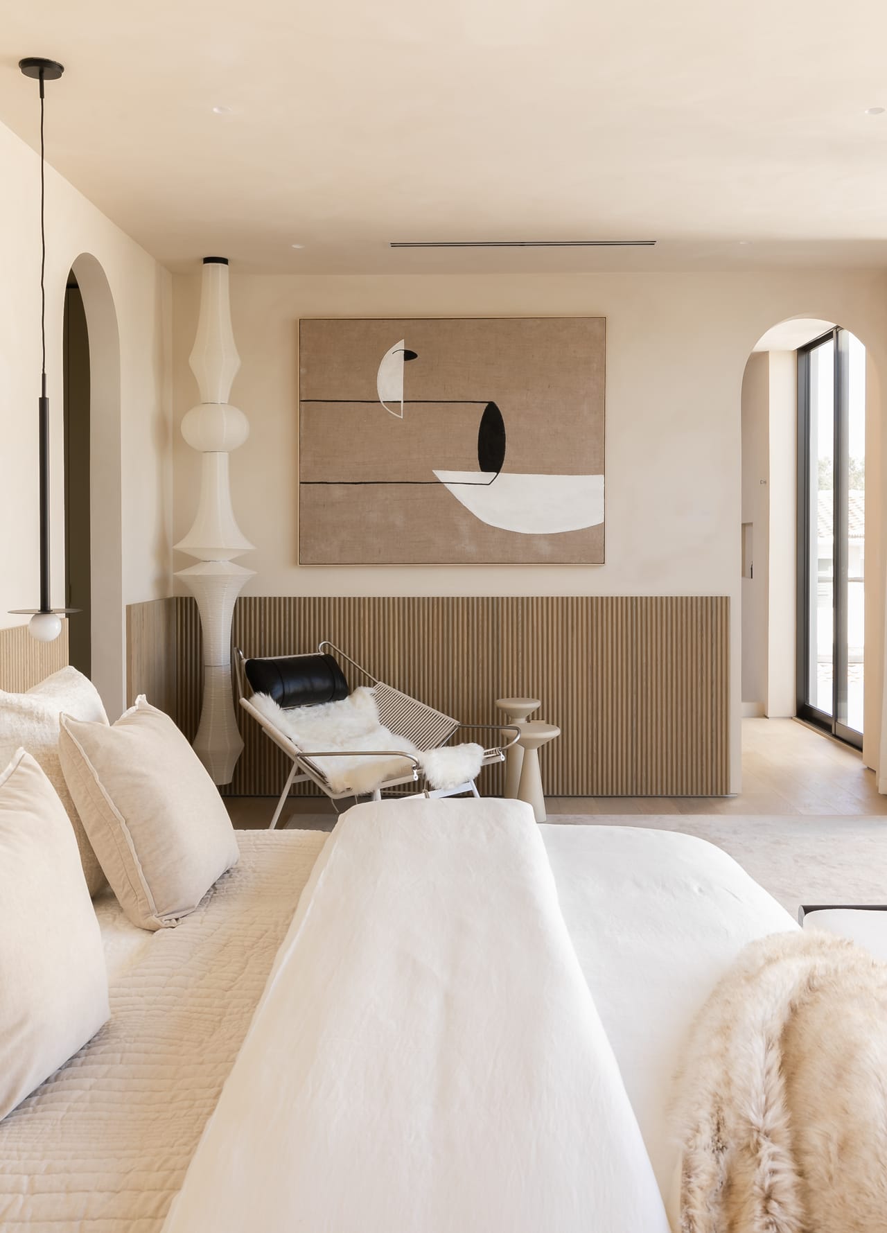 Bedroom with an oak-panelled headboard and abstract artwork