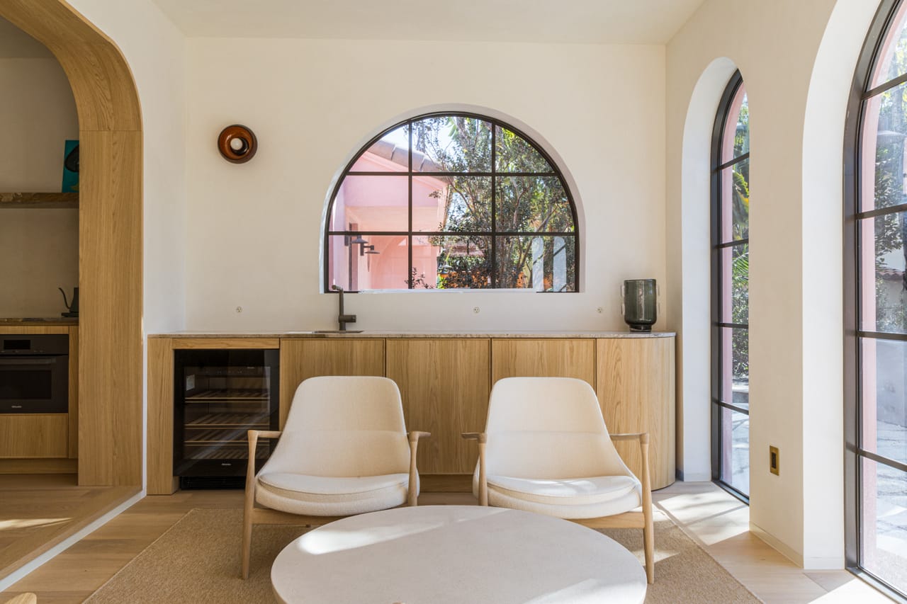 Seating nook with oak cabinetry beneath arched windows