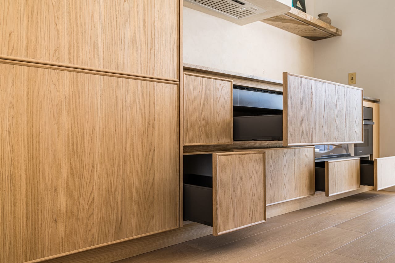 Oak cabinetry wall with open drawers and an integrated media unit