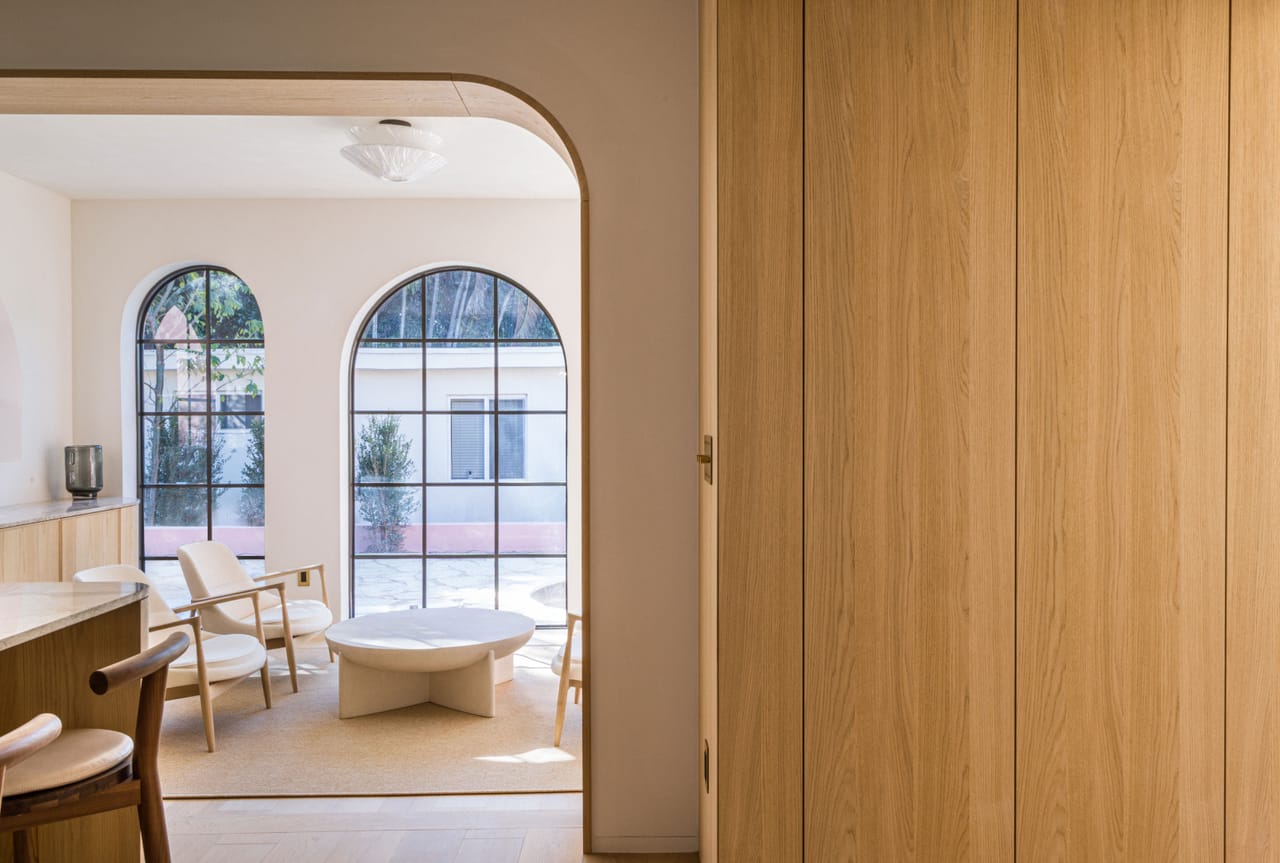 Arched steel windows and oak panelling in a corner seating room