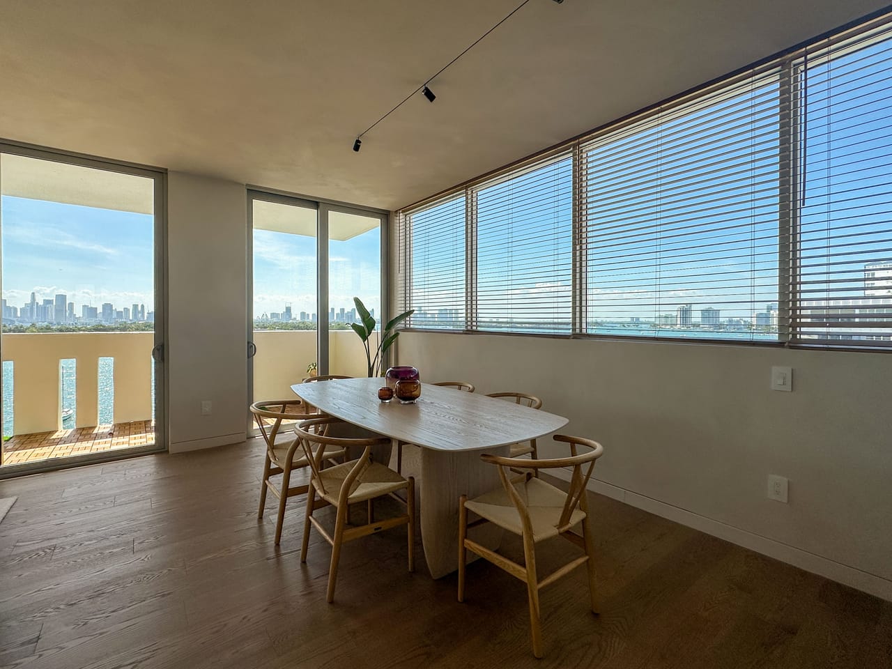 Dining area with an oval table, wishbone chairs, and bay views