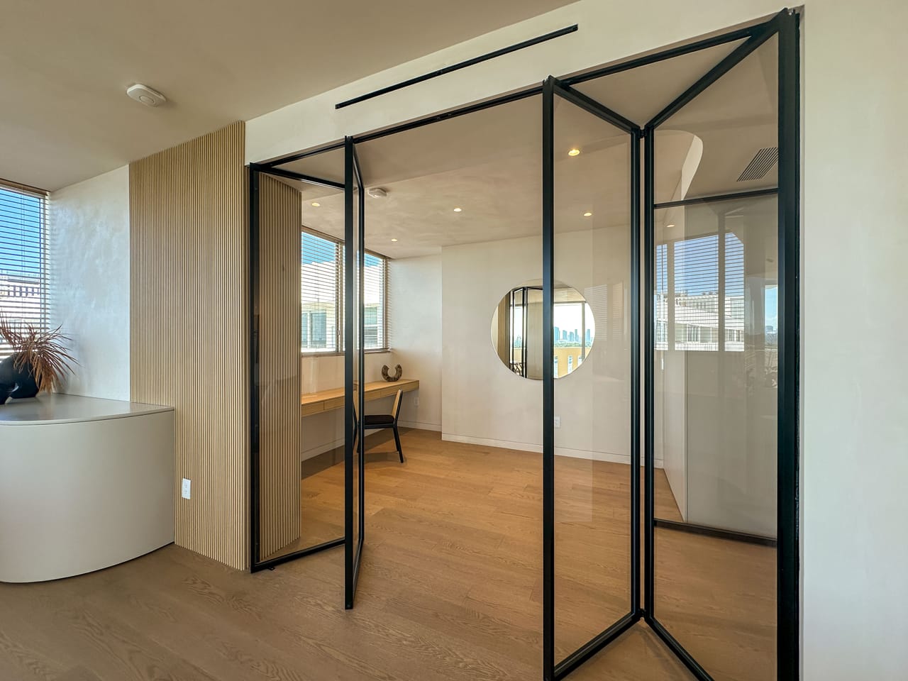 Study nook with folding glass doors and a round mirror
